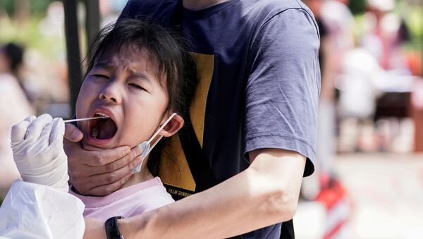 طفل أثناء خضوعه لاختبار الحمض النووي في ووهان المدينة الصينية التي تضررت بشدة من تفشي مرض (COVID-19) الناجم عن فيروس كورونا المستجد - سبوتنيك عربي