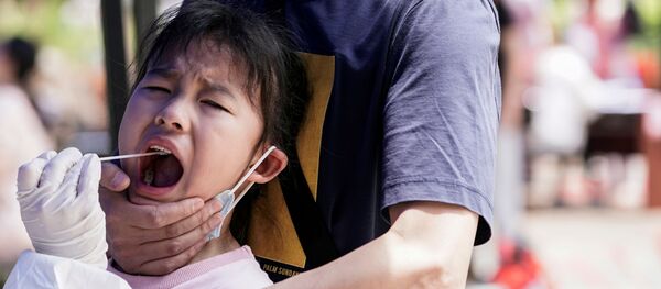 طفل أثناء خضوعه لاختبار الحمض النووي في ووهان المدينة الصينية التي تضررت بشدة من تفشي مرض (COVID-19) الناجم عن فيروس كورونا المستجد - سبوتنيك عربي