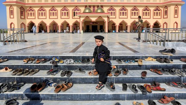 طفل خارج مسجد أثناء صلاة عيد الفطر في مسجد في ولاية لغمان، رغم انتشار فيروس كورونا في أفغانستان 24 مايو 2020 - سبوتنيك عربي
