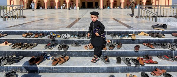 طفل خارج مسجد أثناء صلاة عيد الفطر في مسجد في ولاية لغمان، رغم انتشار فيروس كورونا في أفغانستان 24 مايو 2020 - سبوتنيك عربي