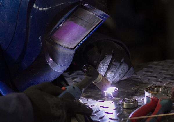 الحرفي الروسي ستانيسلاف تشيرنوفاسيلينكو أثناء العمل على النسخ المصغرة من الدراجات النارية في ورشة عمله - سبوتنيك عربي