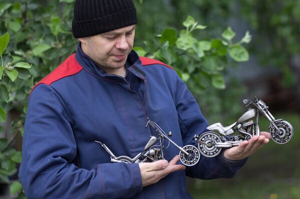 الحرفي الروسي ستانيسلاف تشيرنوفاسيلينكو يعرض (من اليسار إلى اليمين) نسخة مصغرة من دراجة نارية  من طراز هارلي ديفيدسون إيزي رايدر مستوحاة من فيلم كابتن أمريكا، و هارلي ديفيدسونFXDR 450. - سبوتنيك عربي