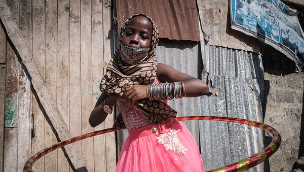 فتاة يتيمة تلعب الهولاهوب أثناء توزيع الطعام والألعاب على الأيتام في 11 دار للأيتام بمناسبة عيد الفطر في كينيا، 25 مايو/ أيار 2020 - سبوتنيك عربي