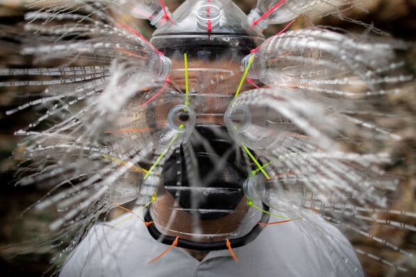 الفنان الفلبيني لييروي نيو (Leeroy New) يرتدي قناعا من صنع يديه، من مواد معاد تدويرها، في ورشة عمله في مدينة كويزون سيتي، الفلبين 28 مايو/ أيار 2020 - سبوتنيك عربي