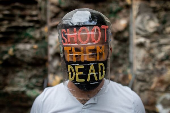 الفنان الفلبيني لييروي نيو (Leeroy New) يرتدي قناعا من صنع يديه، من مواد معاد تدويرها، في ورشة عمله في مدينة كويزون سيتي، الفلبين 28 مايو/ أيار 2020 - سبوتنيك عربي