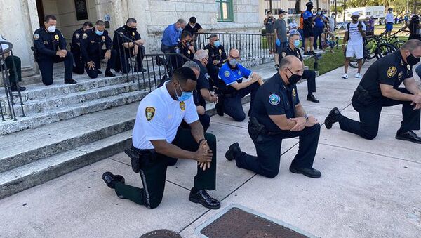 احتجاجات جورج فلويد - عناصر الشرطة الأمريكية يقفون على ركبة واحدة في إطار التضامن مع المتظاهرين في ميامي، الولايات المتحدة - سبوتنيك عربي