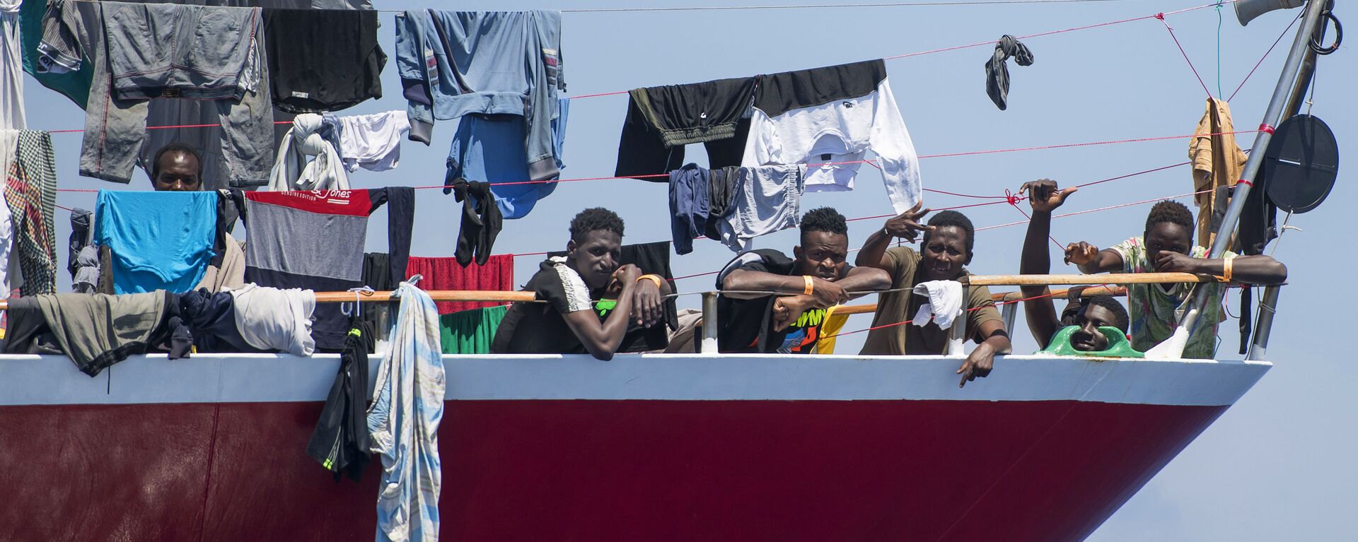 مهاجرون يقومون بنشر غسيلهم على قارب على بعد  20 كم من سواحل مالطا 2 يونيو 2020 - سبوتنيك عربي, 1920, 24.12.2020