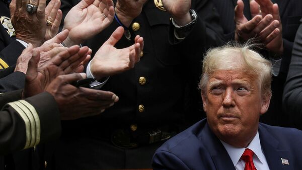 الرئيس الأمريكي دونالد ترامب وسط التصفيق بعد مراسم التوقيع على أمر تنفيذي فيما يخص الإصلاح بالشرطة، في فناء البيت الأبيض في واشنطن، الولايات المتحدة، 16 يونيو  2020 - سبوتنيك عربي