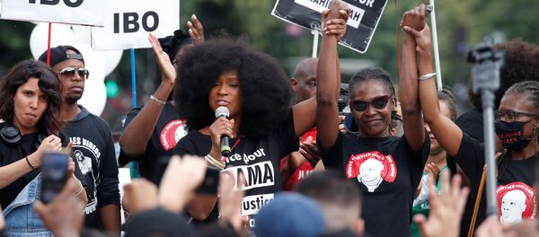 آسا تراوري شقيقة آدام تراوري الفرنسي البالغ من العمر 24 عامًا والذي توفي عام 2016 في حجز الشرطة تتحدث خلال احتجاج على وحشية الشرطة وعدم المساواة العرقية في باريس  - سبوتنيك عربي