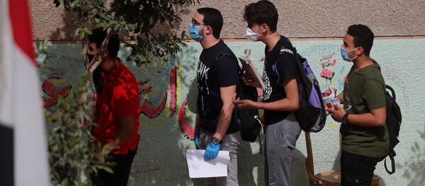 طلاب الثانوية العامة في مصر يرتدون أقنعة واقية أثناء حضورهم في اليوم الأول من الامتحانات وسط مخاوف من تفشي مرض فيروس كورونا - سبوتنيك عربي