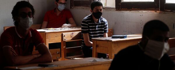 طلاب الثانوية العامة في مصر يرتدون أقنعة واقية أثناء حضورهم في اليوم الأول من الامتحانات وسط مخاوف من تفشي مرض فيروس كورونا - سبوتنيك عربي