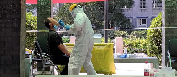 رجل يخضع لاختبار كورونا في موقع اختبار مؤقت في مجمع سكني بعد تفشي جديد لمرض فيروس كورونا في بكين - سبوتنيك عربي