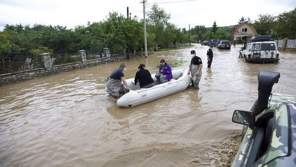 عمال الطوارئ الأوكرانية بإجلاء سكان قرية لانشين التي غمرتها المياه في منطقة إيفانو فرانكيفسك غرب أوكرانيا  - سبوتنيك عربي