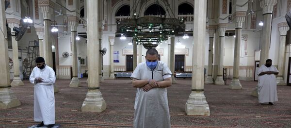المسلمون الذين يرتدون أقنعة واقية يؤدون وسط علامات التباعد الاجتماعي يؤدون أول صلاة الفجر داخل مسجد صلاح الدين بعد أشهر من الإغلاق - سبوتنيك عربي