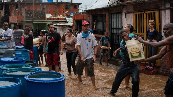 يجمع الناس مياه الشرب في حاويات مختلفة. نظرا لشح في إمدادات المياه، يضطر سكان بعض مناطق مدينة كاراكاس إلى انتظار هطول الأمطار حتى يتمكنوا من الحصول على المياه، فنزويلا 8 يونيو 2020 - سبوتنيك عربي