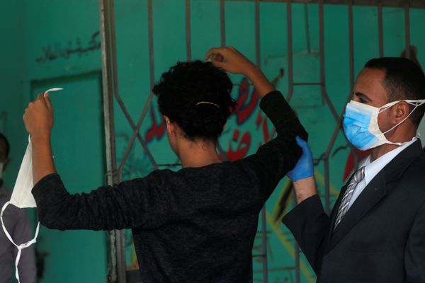 حارس مدرسة يفحص طالبا في الثانوية العامة قبل دخوله قاعة الامتحانات النهائية، وسط مخاوف من تفشي مرض كوفيد-19 في القاهرة، مصر، 21 يونيو 2020 - سبوتنيك عربي