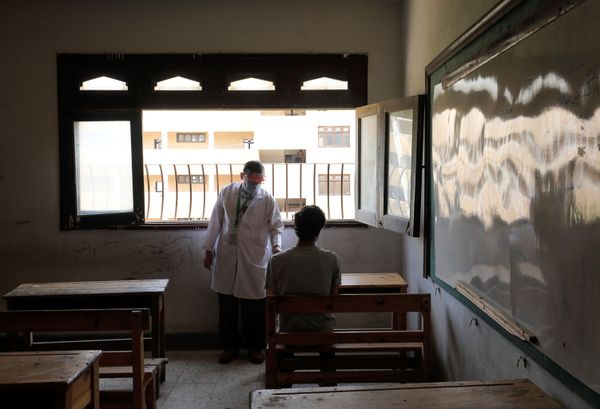 طبيب يفحص طالبا في الثانوية العامة قبل دخوله قاعة الامتحانات النهائية، وسط مخاوف من تفشي مرض كوفيد-19 في القاهرة، مصر، 21 يونيو 2020 - سبوتنيك عربي