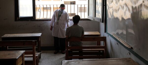 طبيب يفحص طالبا في الثانوية العامة قبل دخوله قاعة الامتحانات النهائية، وسط مخاوف من تفشي مرض كوفيد-19 في القاهرة، مصر، 21 يونيو 2020 - سبوتنيك عربي