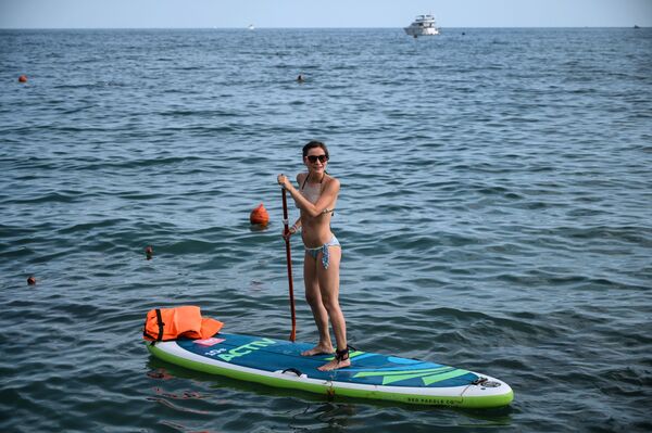 فتاة تقف على لوح لركوب الأمواج في المنتجع الصيفي تسيرك في سوتشي فتاة تقف على لوح لركوب الأمواج في المنتجع الصيفي تسيرك في سوتشي - سبوتنيك عربي